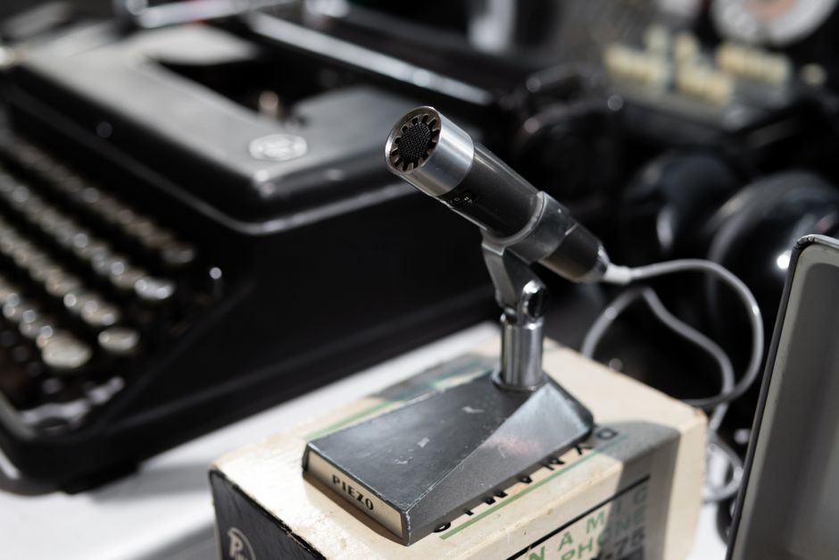 Close-up of a vintage microphone with a typewriter, capturing a retro aesthetic in detail.